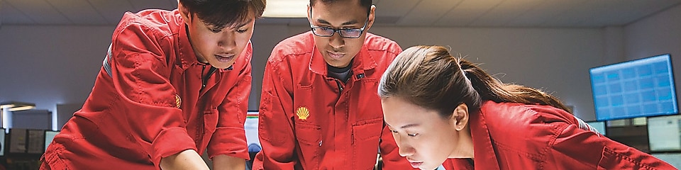 Three employees reviewing plans