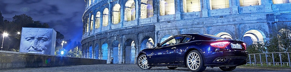 Car parked outside of the Colosseum in Rome at night