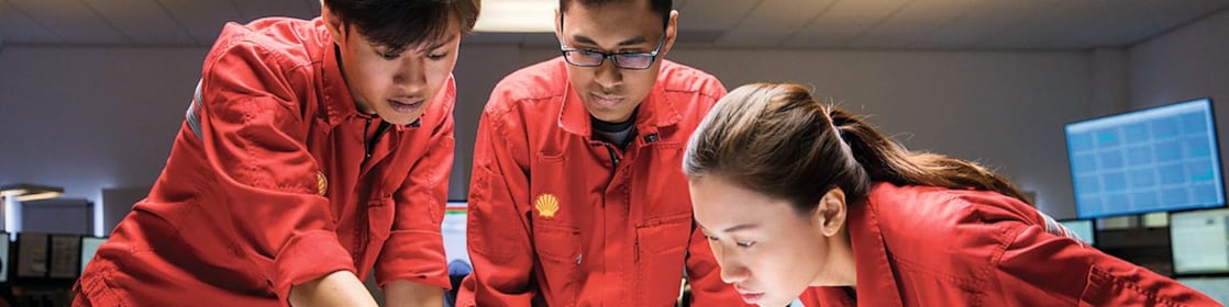 Tiga karyawan sedang meninjau rencana