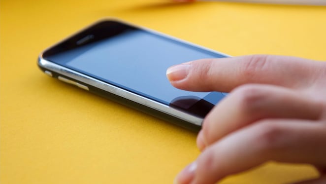 Hand hovering over mobile phone