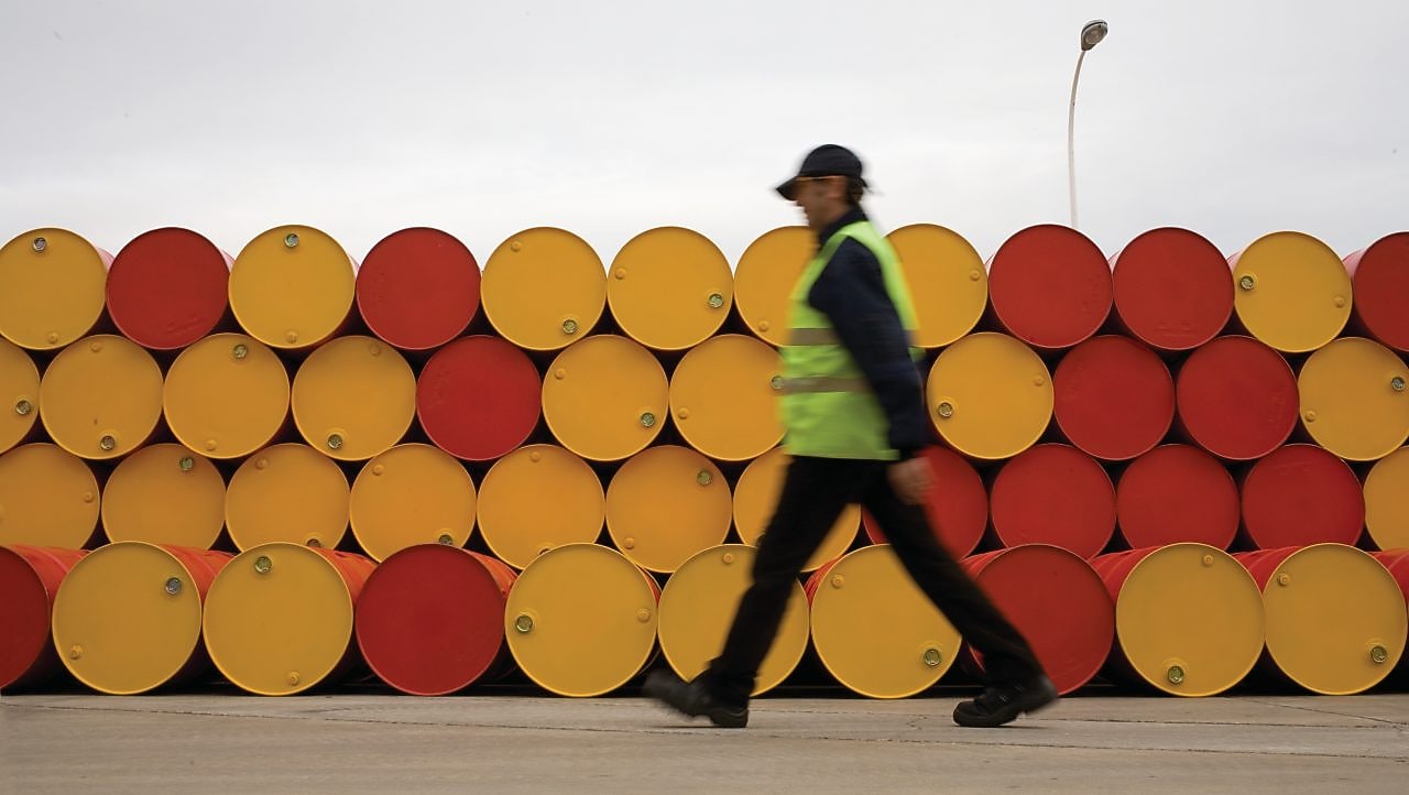 pria menggelindingkan barel pelumas