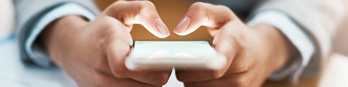 Two hands shown using a blackberry device to send an email