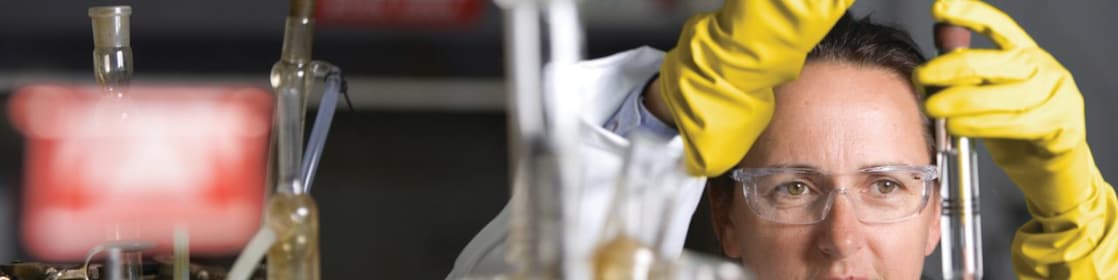 wanita mengenakan kacamata pelindung sedang melakukan eksperimen lab