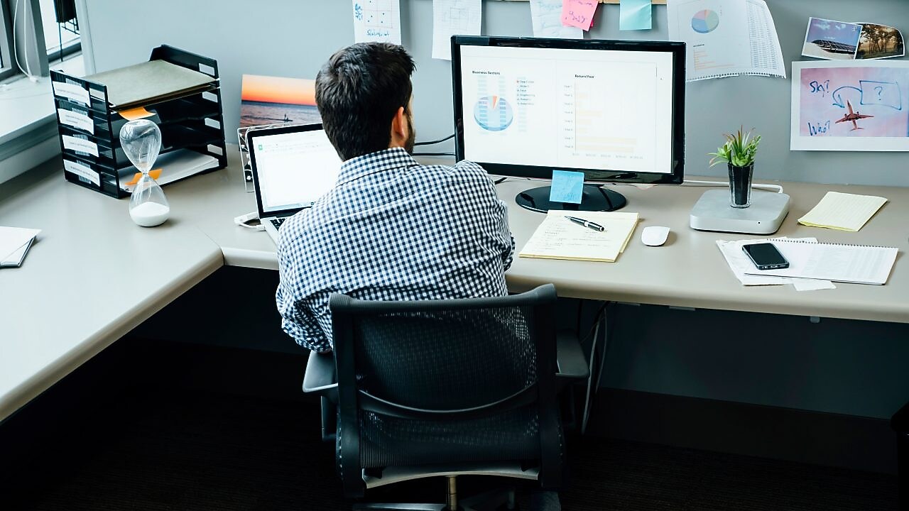 Businessman using laptop and computer in office