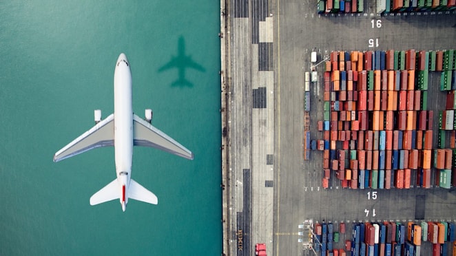Airplane flying over container port
