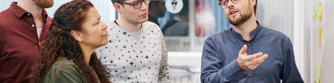three men and women looking at a chart
