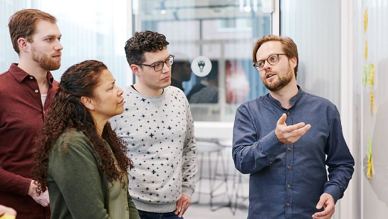 three men and women looking at a chart