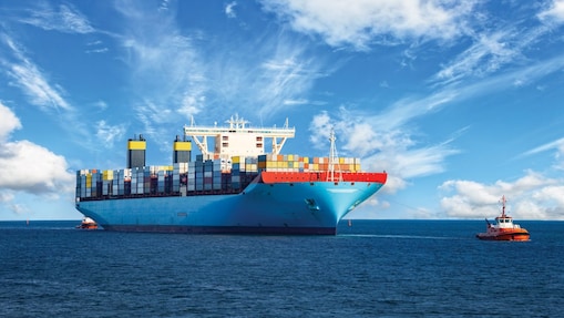 Large cargo vessel being pulled by tugboat