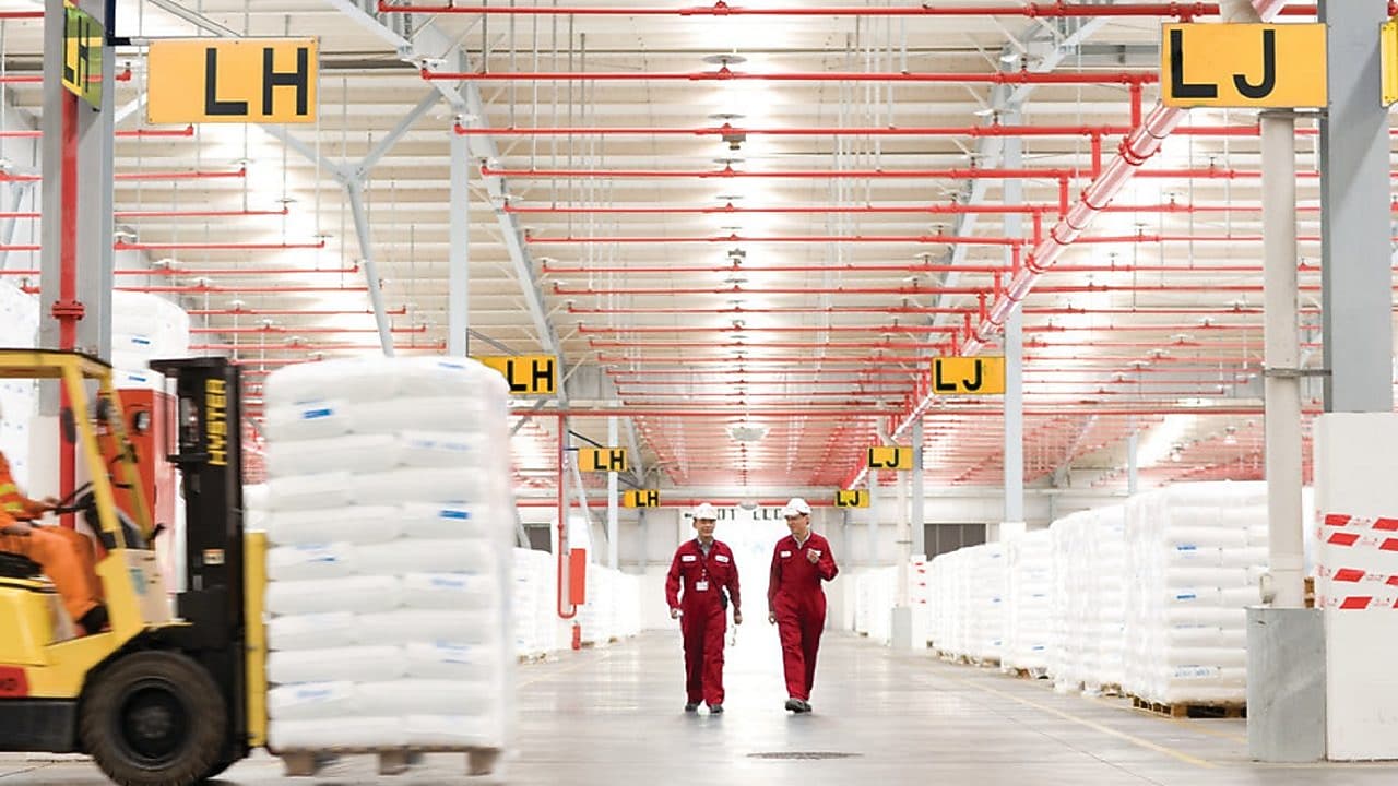 Dua karyawan sedang berjalan di pabrik