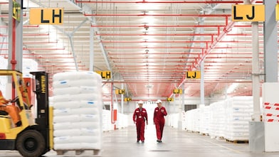 Dua karyawan sedang berjalan di pabrik