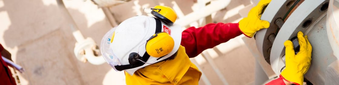 Pekerja mengenakan masker pelindung dan sarung tangan