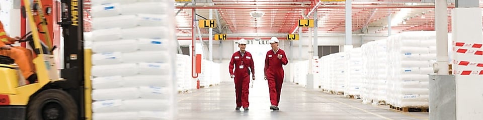 Dua karyawan sedang berjalan di pabrik