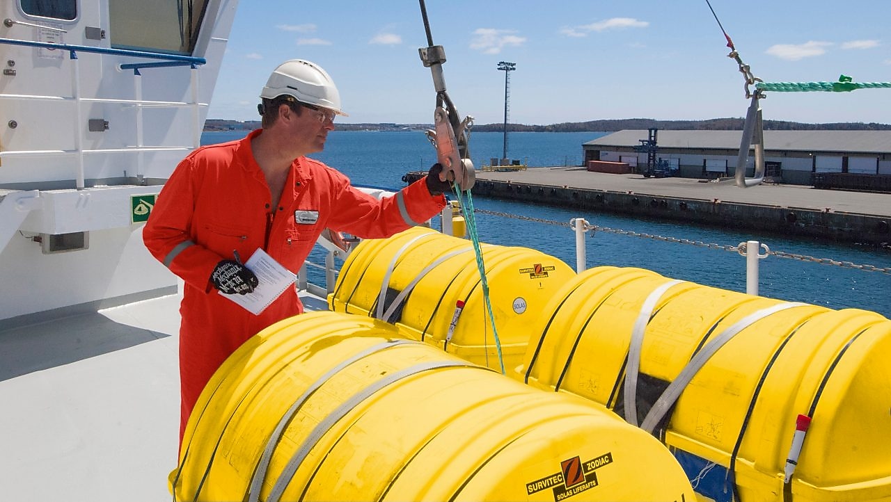 Karyawan memeriksa peralatan pada perahu yang ditambatkan