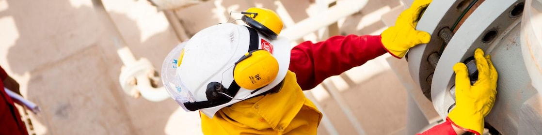 Pekerja mengenakan masker pelindung dan sarung tangan