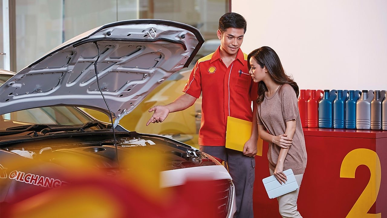Mekanik Shell sedang menjelaskan penggantian oli kepada konsumen
