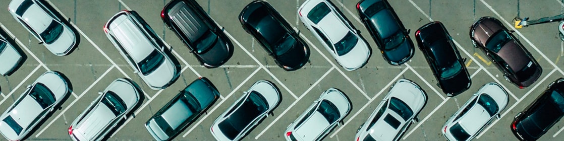 Deretan mobil di parkiran dan salah satunya terparkir miring dengan roda depan berbelok tajam.