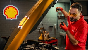 Seseorang sedang mengecek oli mesin mobil secara mandiri.