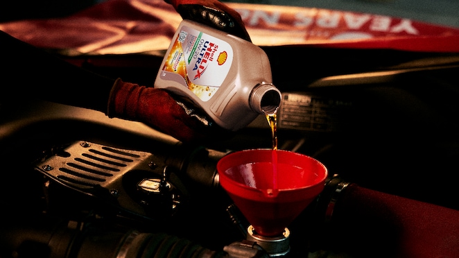 Shell Helix Ultra sedang dituang ke dalam mesin mobil.