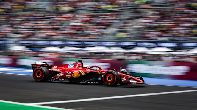 Mobil balap sedang melaju kencang di sirkuit.