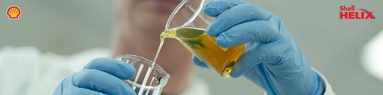 seorang pria menuangkan minyak ke dalam labu kaca