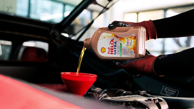 Orang sedang mengganti oli dan filter oli.