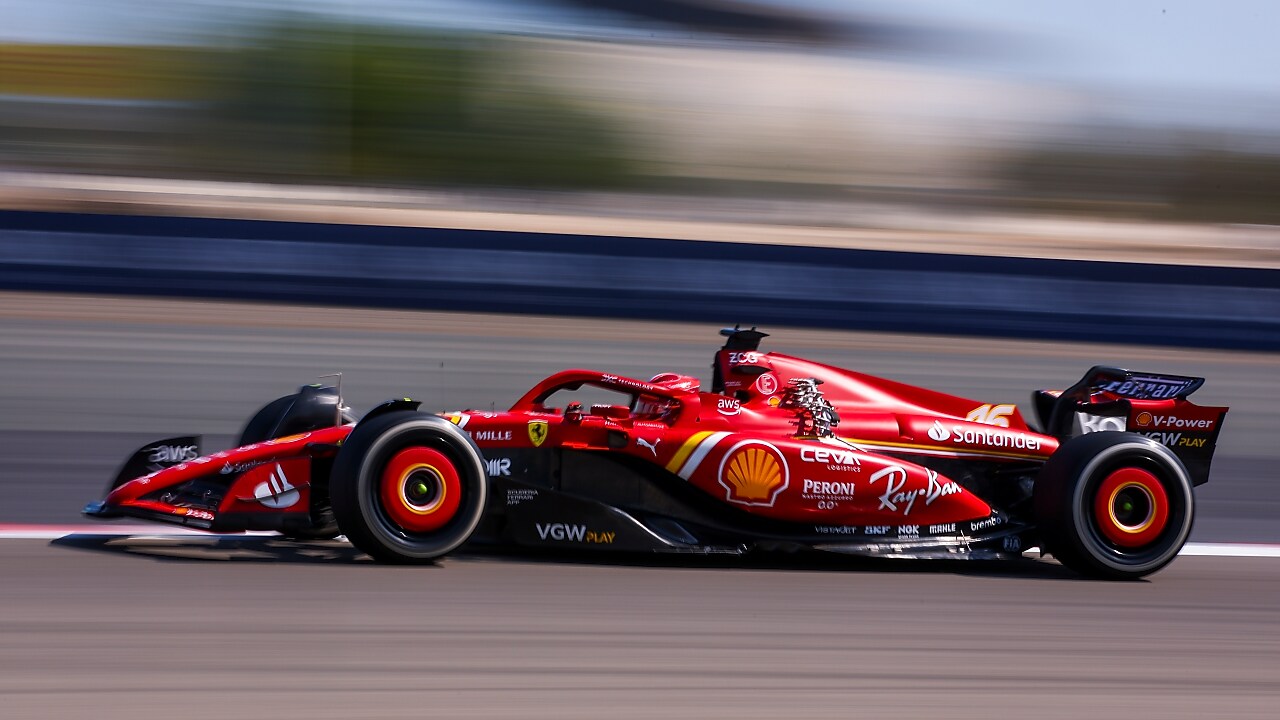 Tampak samping mobil balap Ferrari yang sedang melaju di sirkuit.