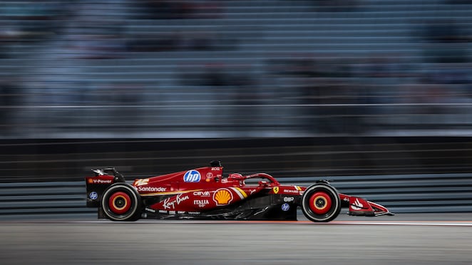 Tampak samping mobil balap Ferrari yang sedang melaju di sirkuit.