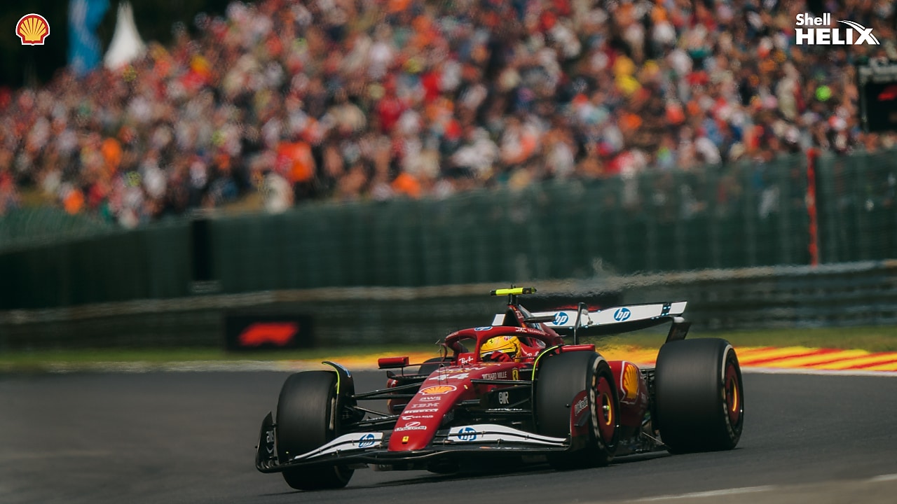 Tampak depan mobil balap Ferrari yang sedang melaju di sirkuit. 