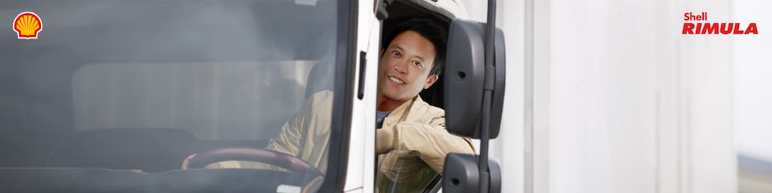 Seorang sopir sedang mengendarai truk miliknya.