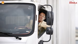 Seorang sopir sedang mengendarai truk miliknya.