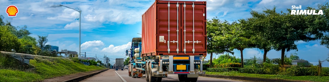 Truk berat melaju di tengah perjalanan.