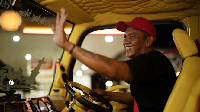 Agus Tegar sedang mengendarai truk berat miliknya.