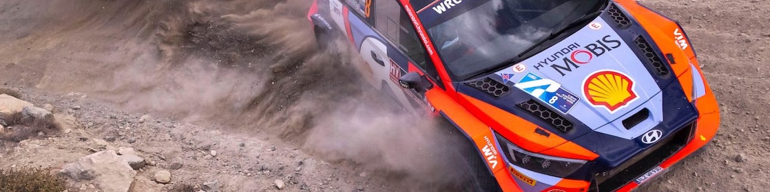 Mobil reli meluncur di tikungan dalam kejuaraan reli dunia