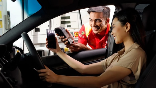 Man giving card from car window petrol station