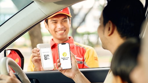 Man giving card from car window petrol station