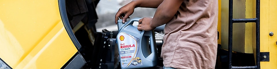 Pengemudi truk mengganti oli kendaraannya dengan Shell Rimula LD4 Extra