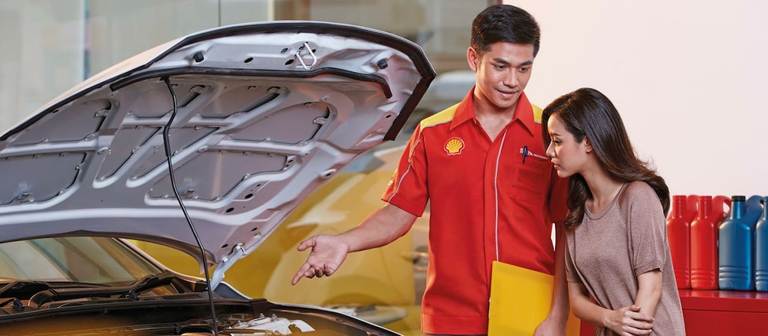 Mekanik Shell sedang menjelaskan penggantian oli kepada konsumen