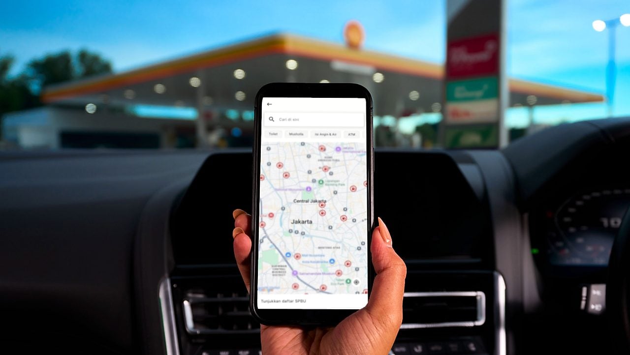 Seorang wanita muda membaca instruksi yang ditampilkan di layar navigasi yang terpasang di mobilnya