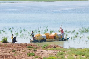 Penduduk lokal menyeberangi Rawa Hawizeh yang tergenang banjir, di dekat proyek Majnoon di Irak