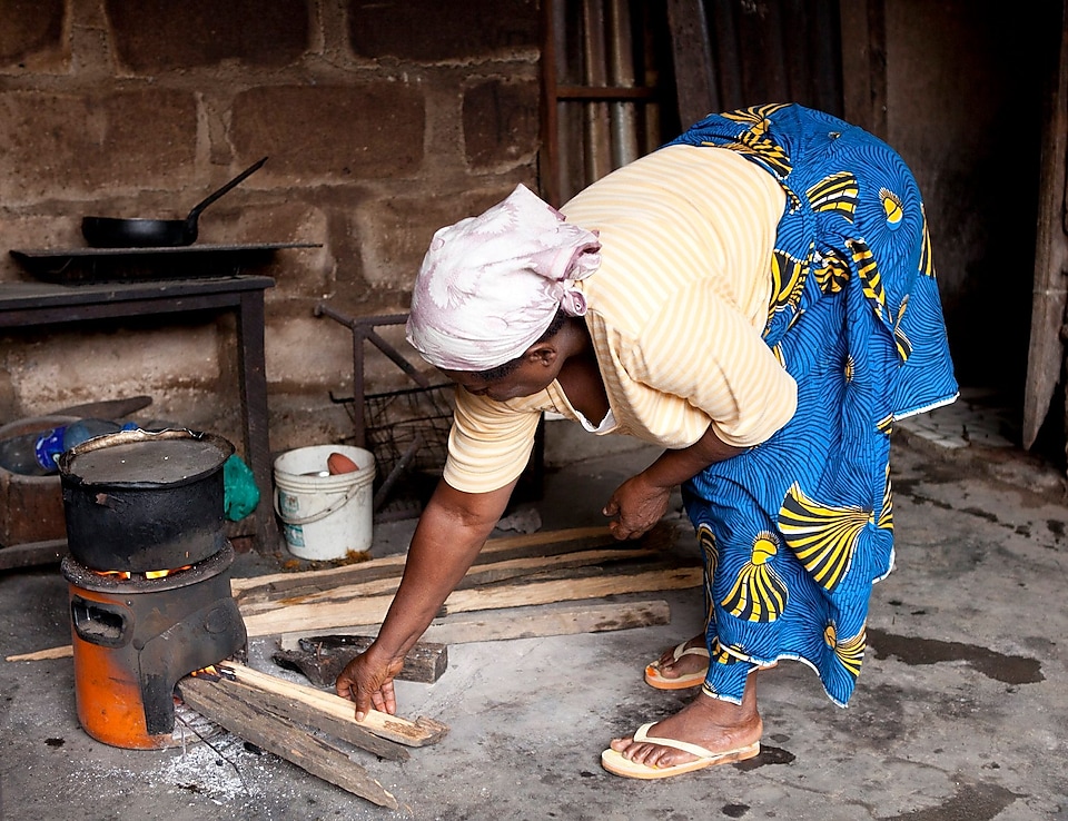 Seorang wanita sedang memasak dengan kompor di Nigeria