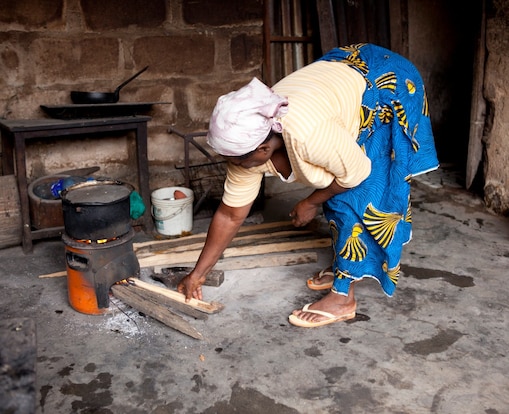 Seorang wanita sedang memasak dengan kompor di Nigeria